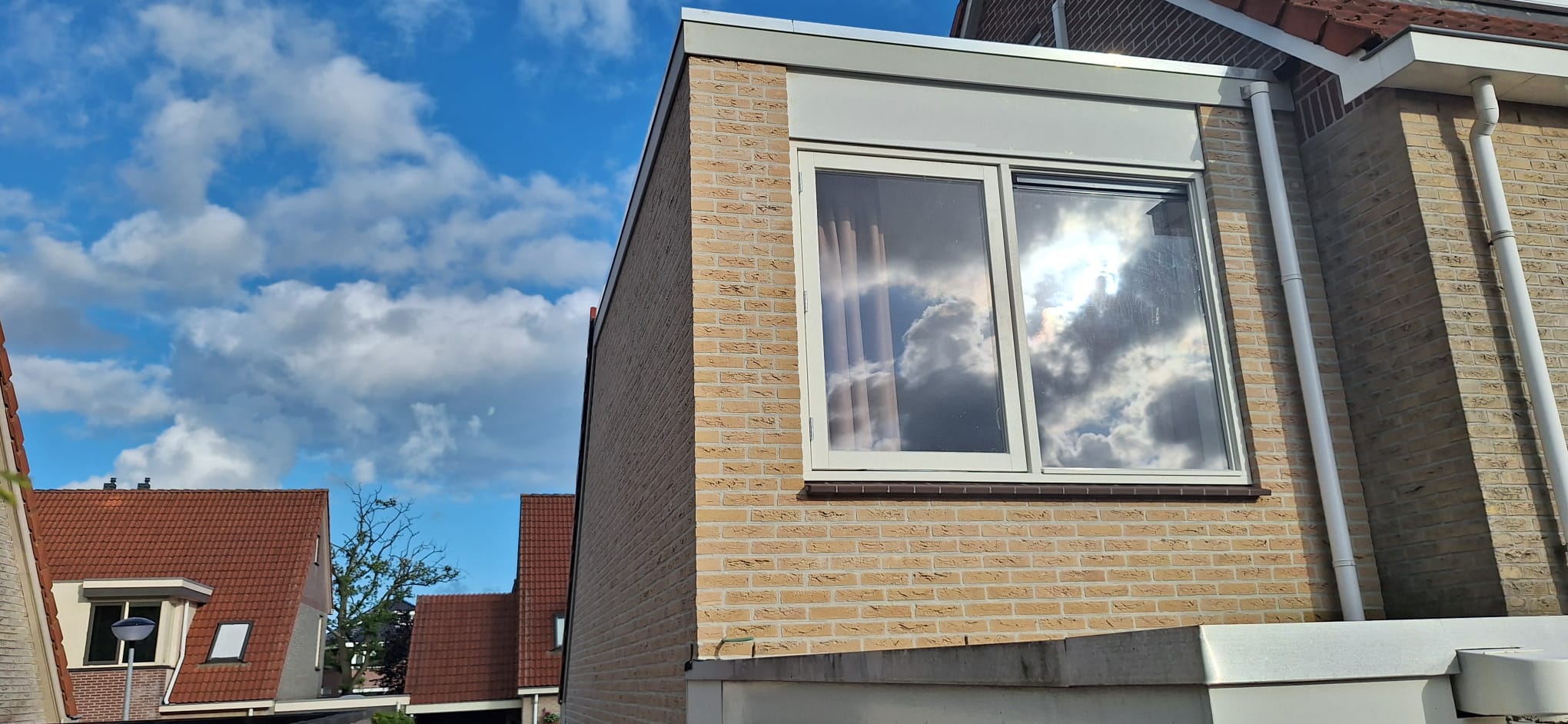 Dakopbouw buitenzijde met metselwerk en raam