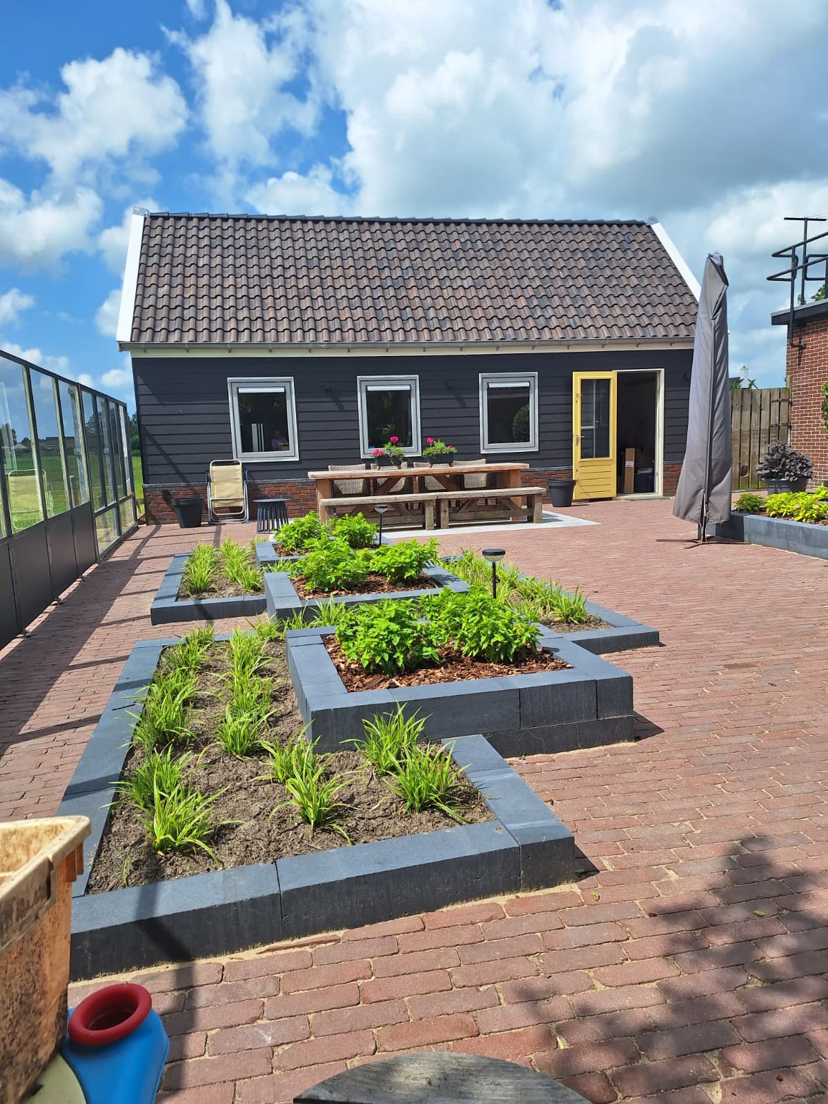 Voltooide schuur in De Goorn met aangelegde tuin en plantenbakken